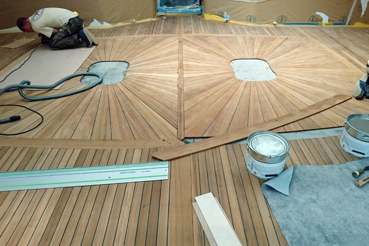 Fitting teak decking on board of yacht by Duca Solutions